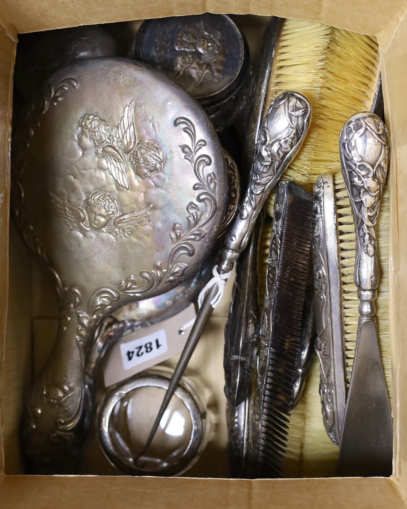 A late Victorian five piece silver Reynolds angel dressing table set, maker William Comyns, four assorted silver lidded glass Reynolds angel toilet jars and sundries